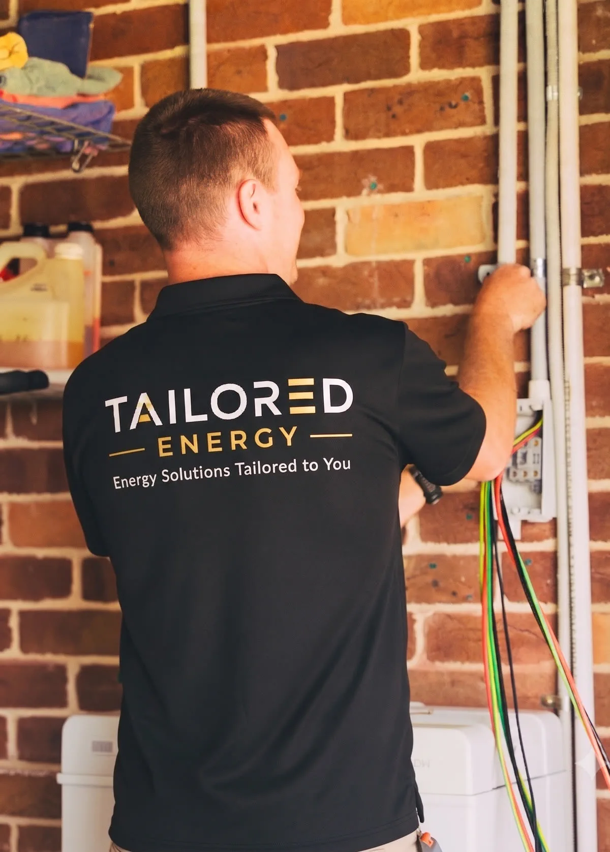 Tailored Energy electrician wiring a switchboard during an Auckland solar installation